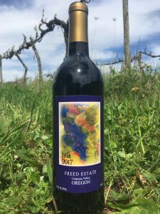 Freed Estate Winery bottle of Syrah in the vineyard.