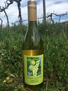 Freed Estate Winery bottle of Viognier in the vineyard.